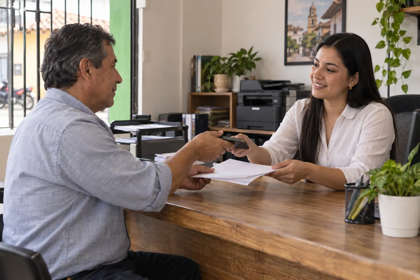 Asesora atendiendo a un cliente en una oficina de SOAT